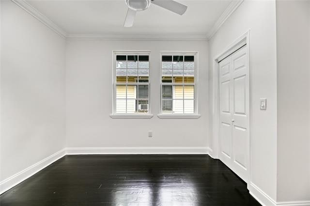 unfurnished room featuring dark hardwood / wood-style flooring, ceiling fan, and ornamental molding