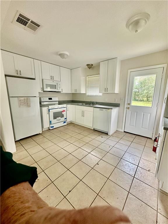 kitchen featuring white cabinets, white appliances, sink, and light tile patterned flooring