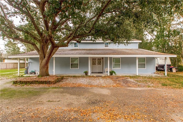 country-style home featuring fence and covered porch
