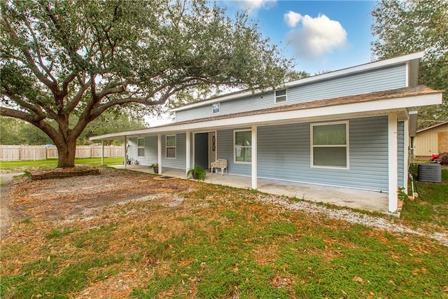 back of house with central AC unit and a yard