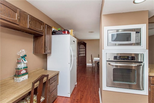 kitchen with stainless steel appliances, wood finished floors, light countertops, dark brown cabinets, and baseboards