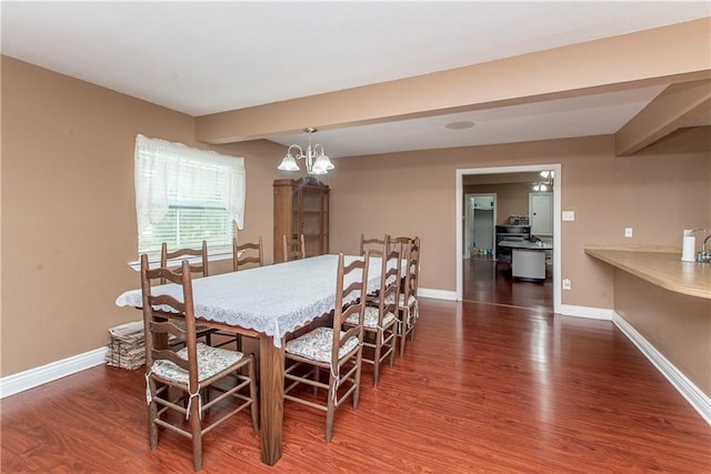 dining room with wood finished floors, baseboards, a chandelier, and beam ceiling
