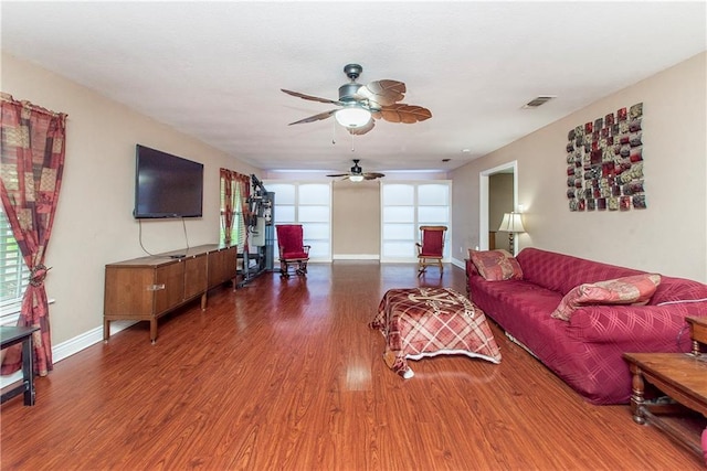 living room featuring ceiling fan, wood finished floors, and baseboards