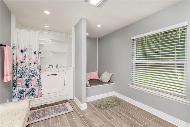 bathroom with baseboards, wood finished floors, and recessed lighting