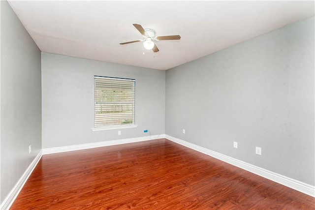 unfurnished room with a ceiling fan, wood finished floors, and baseboards