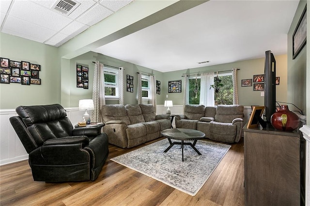 living room with hardwood / wood-style flooring and a drop ceiling