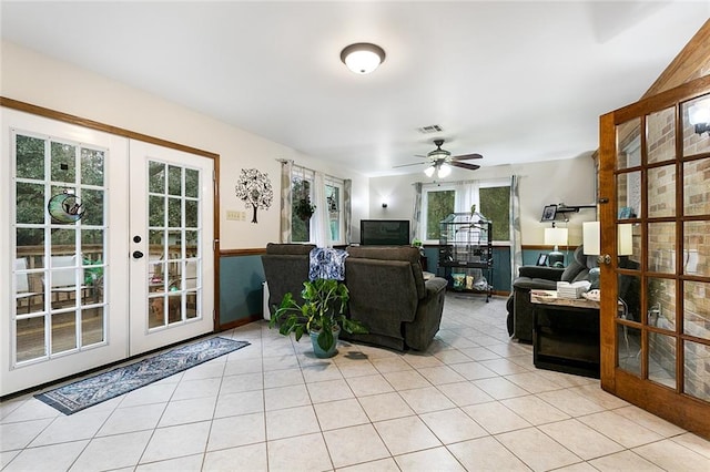 tiled living room with ceiling fan, french doors, and plenty of natural light