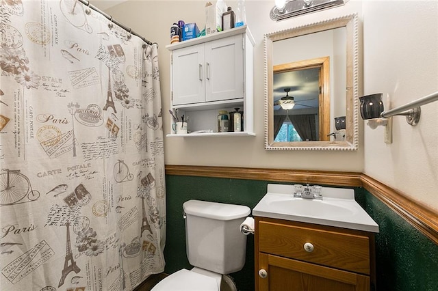 bathroom featuring walk in shower, vanity, toilet, and ceiling fan