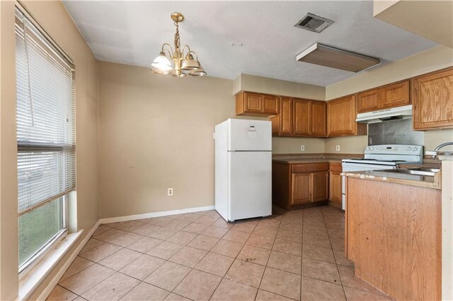 kitchen with an inviting chandelier, light tile patterned floors, white appliances, pendant lighting, and sink