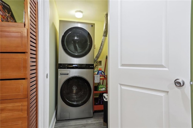 laundry room featuring stacked washer and dryer and hardwood / wood-style flooring