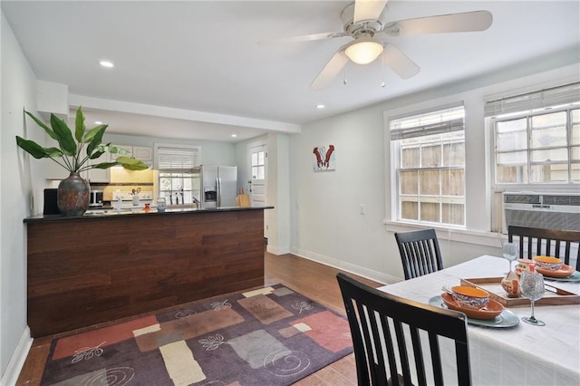 dining area featuring dark hardwood / wood-style floors, a wealth of natural light, cooling unit, and ceiling fan