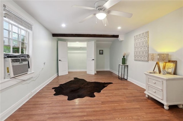 bedroom featuring beam ceiling, ceiling fan, light hardwood / wood-style flooring, cooling unit, and a closet