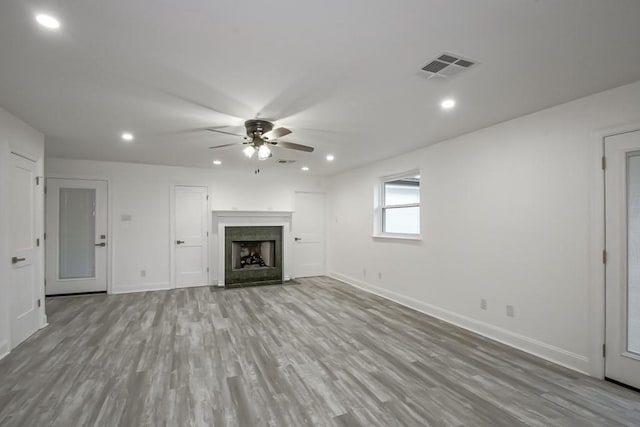 unfurnished living room featuring ceiling fan and light hardwood / wood-style flooring