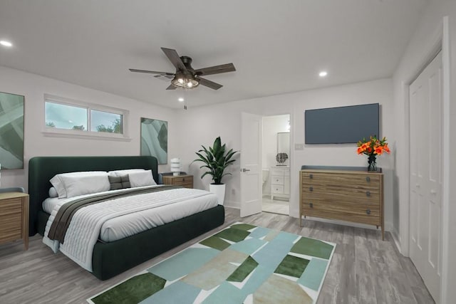 bedroom with hardwood / wood-style flooring, connected bathroom, ceiling fan, and a closet