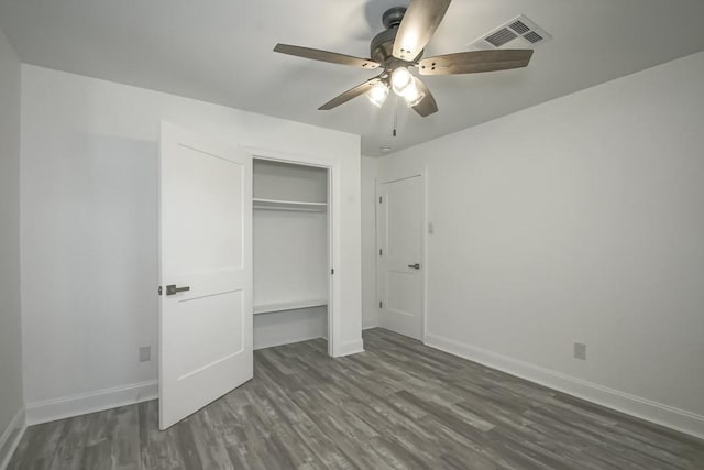 unfurnished bedroom with ceiling fan, dark hardwood / wood-style floors, and a closet