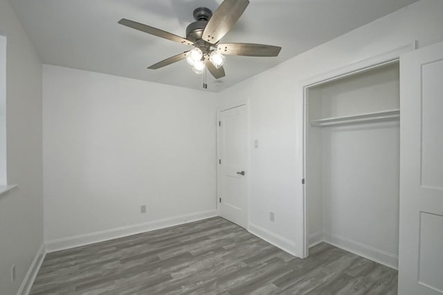 unfurnished bedroom featuring hardwood / wood-style floors, ceiling fan, and a closet