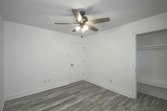 unfurnished bedroom featuring ceiling fan, dark hardwood / wood-style floors, and a closet