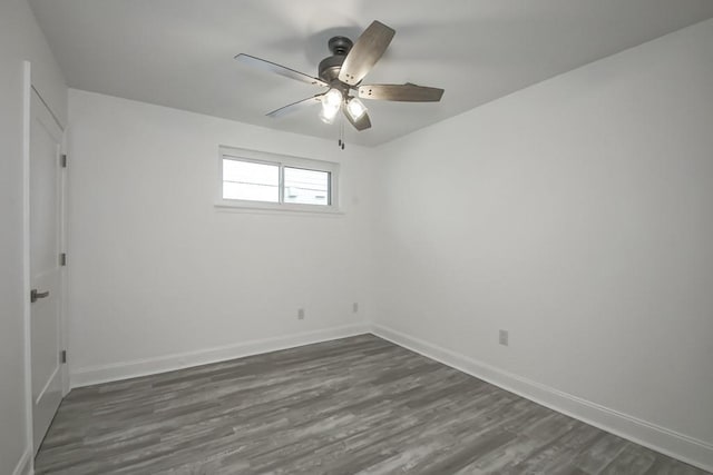 empty room featuring dark wood-type flooring and ceiling fan