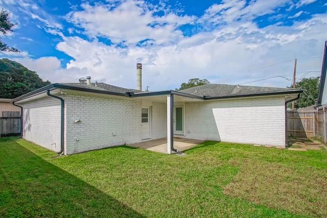 rear view of house featuring a patio area and a lawn