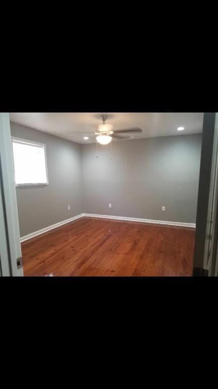 spare room with hardwood / wood-style flooring and ceiling fan