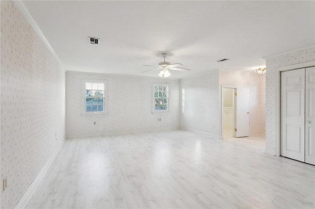 unfurnished room featuring ceiling fan, crown molding, and light hardwood / wood-style flooring