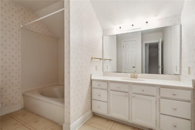 bathroom with a bathing tub, vanity, and vaulted ceiling