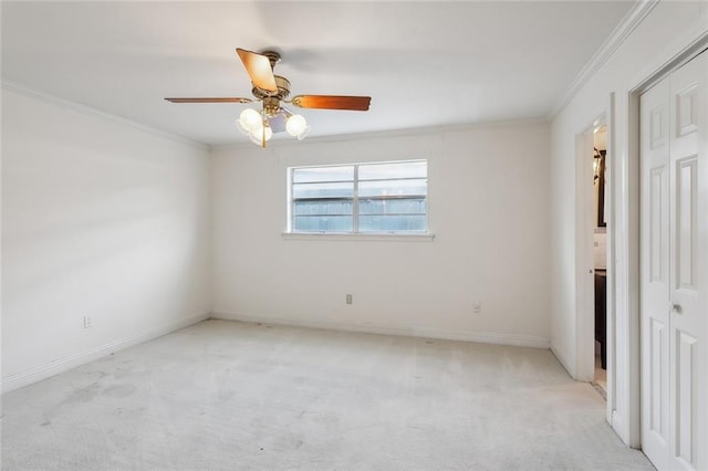 spare room with light carpet, ceiling fan, and crown molding