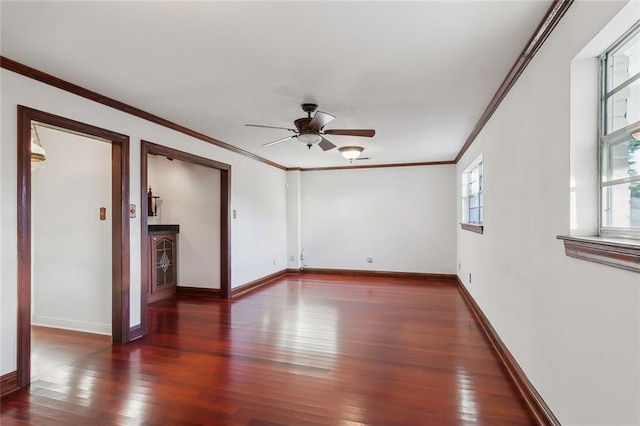 spare room featuring dark hardwood / wood-style flooring, ornamental molding, and ceiling fan