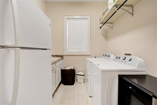 washroom with washer and clothes dryer and cabinets