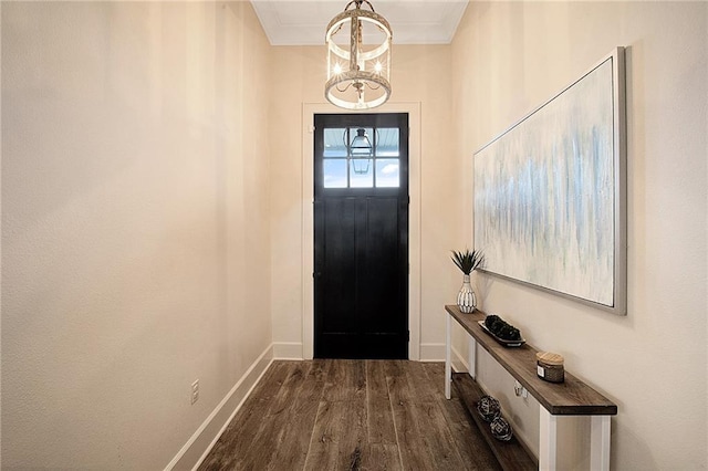 foyer with a chandelier, ornamental molding, and dark wood-type flooring