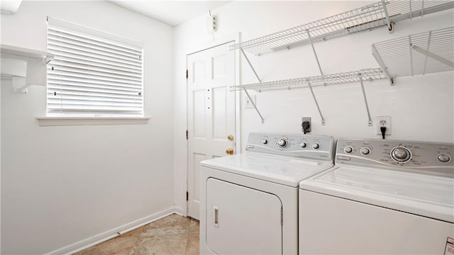washroom with baseboards, washer and dryer, and laundry area