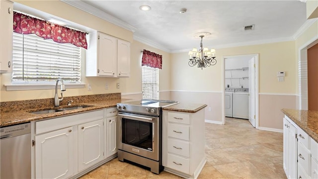 kitchen with stainless steel appliances, a peninsula, a sink, a chandelier, and separate washer and dryer