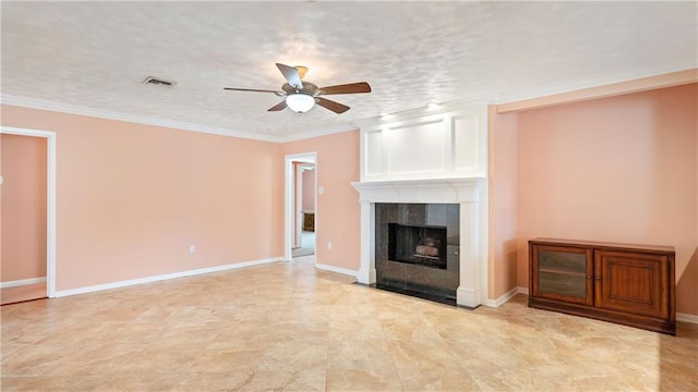 unfurnished living room with a tiled fireplace, a textured ceiling, ceiling fan, and crown molding