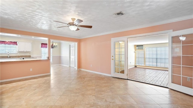 unfurnished living room featuring ceiling fan, crown molding, a sink, and visible vents