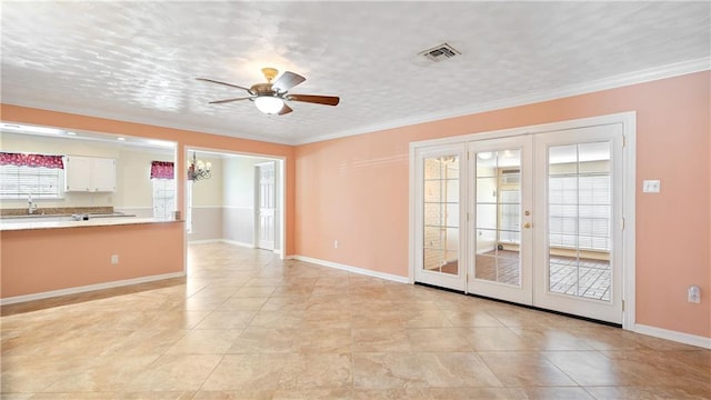 unfurnished living room featuring visible vents, a sink, french doors, crown molding, and ceiling fan