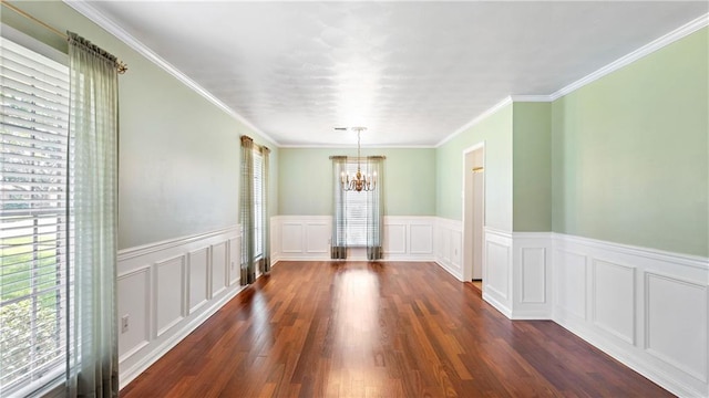 empty room featuring dark wood-type flooring, crown molding, and a chandelier