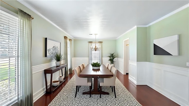 dining space featuring a wainscoted wall, a chandelier, ornamental molding, and dark wood-style flooring