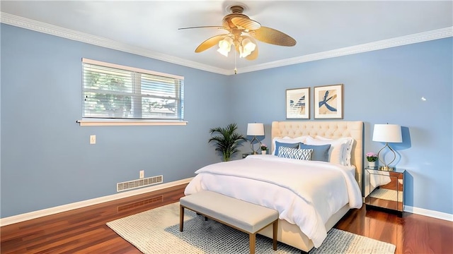 bedroom with baseboards, visible vents, wood finished floors, ceiling fan, and crown molding