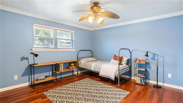 bedroom featuring wood finished floors, crown molding, baseboards, and a ceiling fan