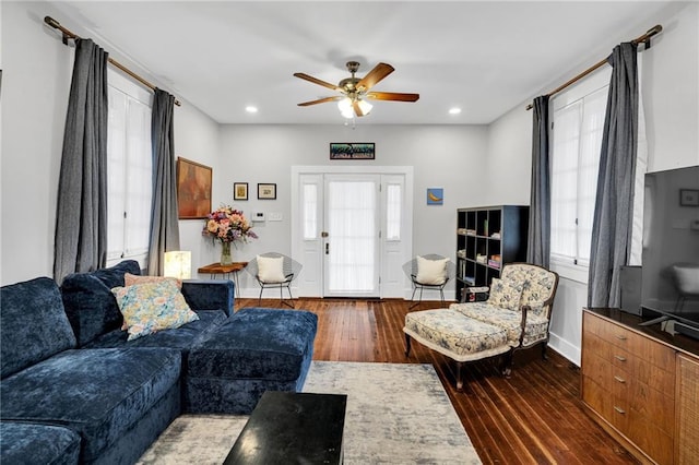 living room featuring ceiling fan and dark wood-type flooring