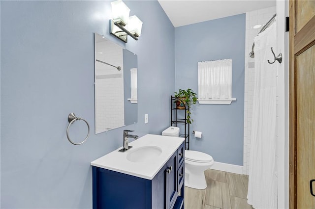 bathroom featuring vanity, toilet, and walk in shower