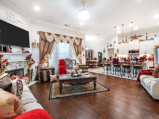 living room with crown molding, a fireplace, and dark wood-type flooring