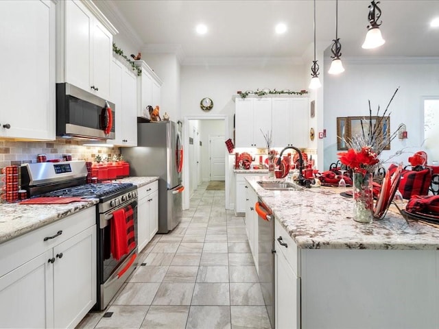 kitchen featuring sink, crown molding, decorative light fixtures, white cabinetry, and stainless steel appliances