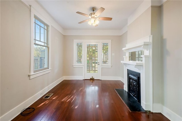 unfurnished living room featuring ceiling fan and dark hardwood / wood-style floors