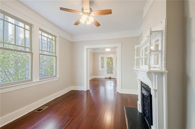 living room with dark hardwood / wood-style floors, ceiling fan, and a healthy amount of sunlight