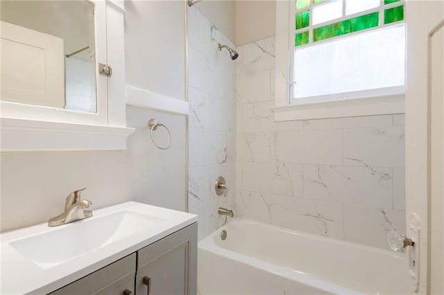 bathroom with tiled shower / bath, vanity, and plenty of natural light