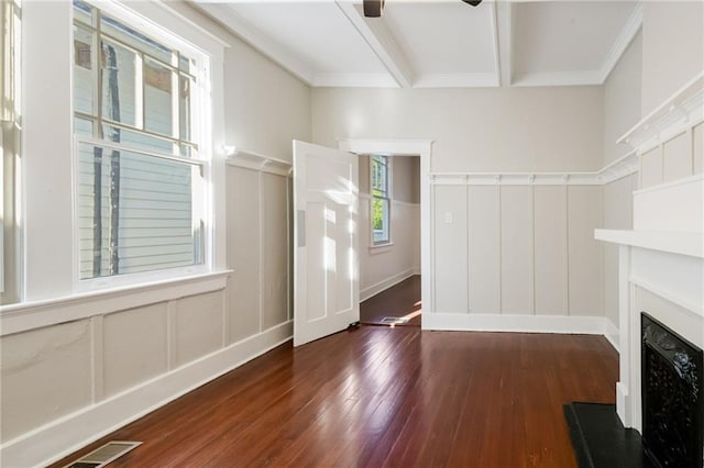 unfurnished living room featuring crown molding, dark hardwood / wood-style flooring, beamed ceiling, and ceiling fan