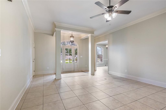 tiled empty room with ceiling fan with notable chandelier, decorative columns, and ornamental molding