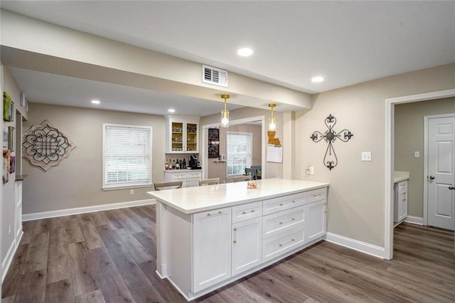 kitchen featuring a wealth of natural light, white cabinets, pendant lighting, and dark hardwood / wood-style floors