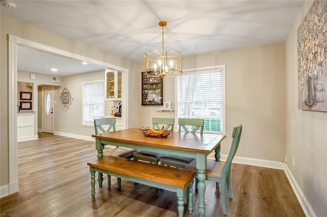 dining area featuring plenty of natural light, an inviting chandelier, and hardwood / wood-style flooring